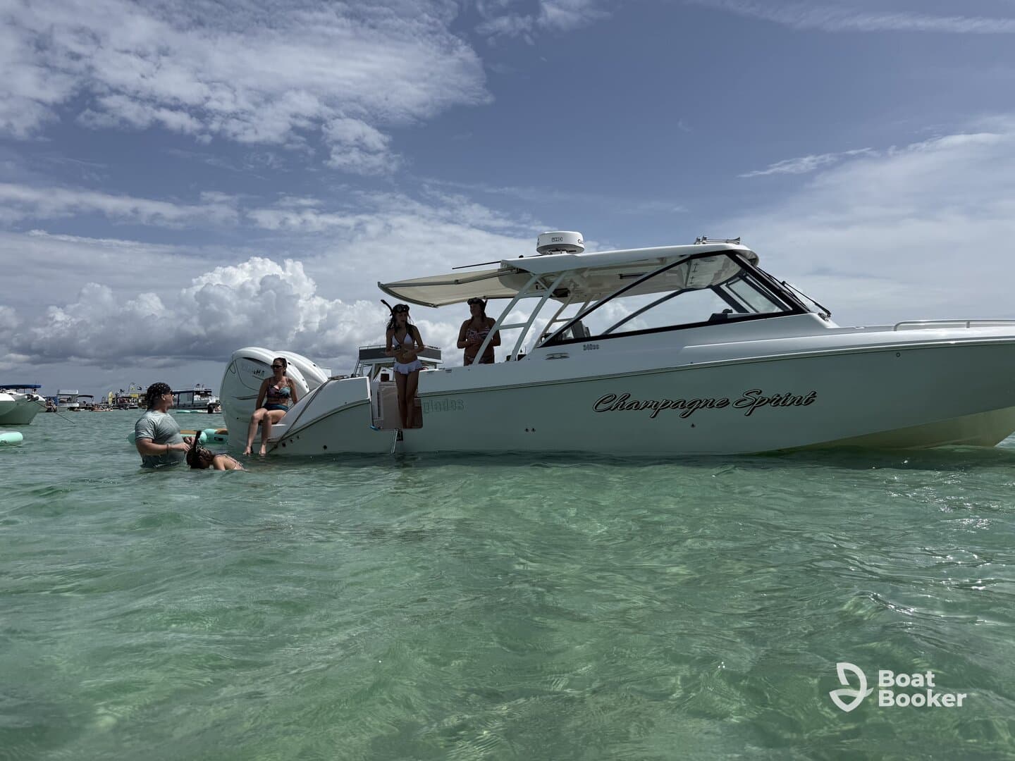A lively group enjoys a day on the water with the 'Champagne Sprint' boat, swimming and having fun in the clear turquoise waters.