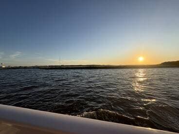 A serene sunset view over the water, capturing the tranquil beauty of the evening sky — perfect for romantic boat rides or peaceful escapes.