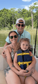 A joyful family enjoys a day on the boat, with a child safely wearing a life jacket — perfect for summer adventures on the water.
