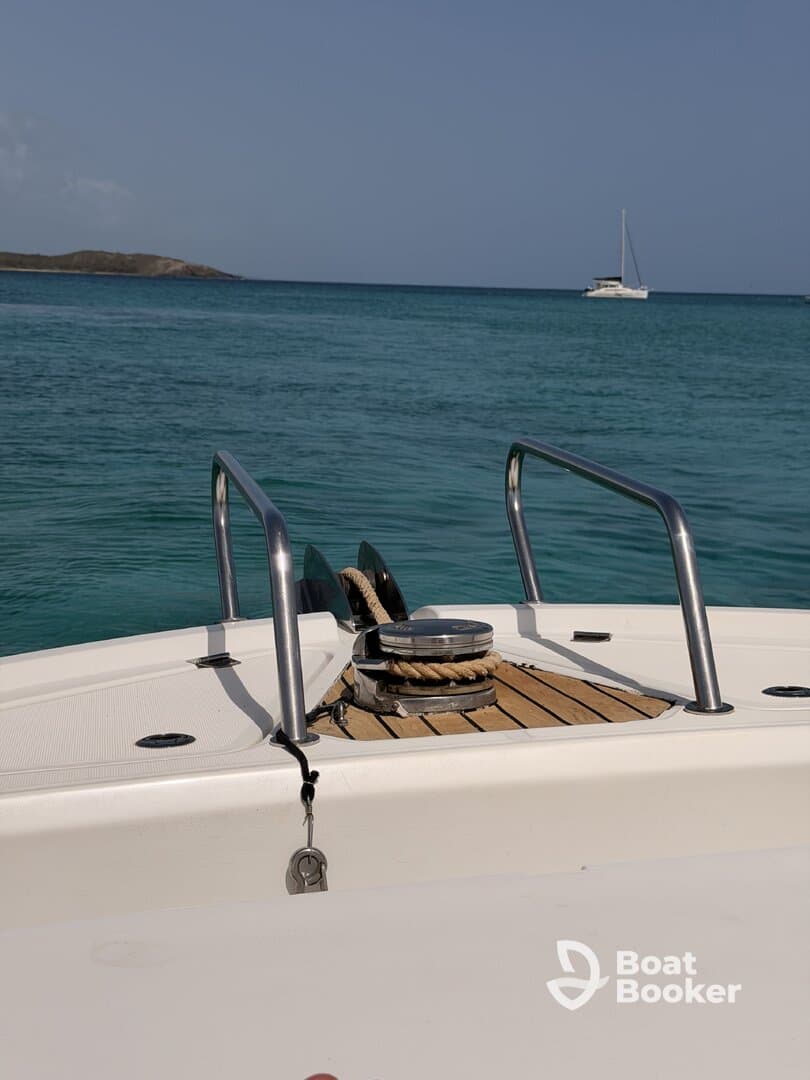 A clear view of the front deck of a boat, showcasing the sleek design and tranquil turquoise waters in the background, perfect for a day on the water.