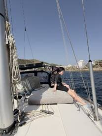 Two friends enjoy a relaxing moment on the deck of a sailboat, soaking in the sun and sea breeze — a perfect snapshot of a sailing adventure.