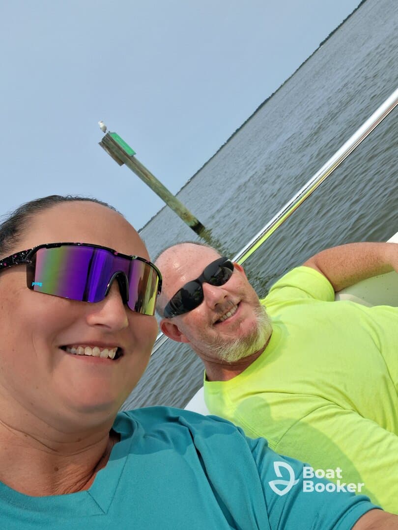 A cheerful couple takes a selfie while enjoying a day on the water, capturing the joy of their boating experience.