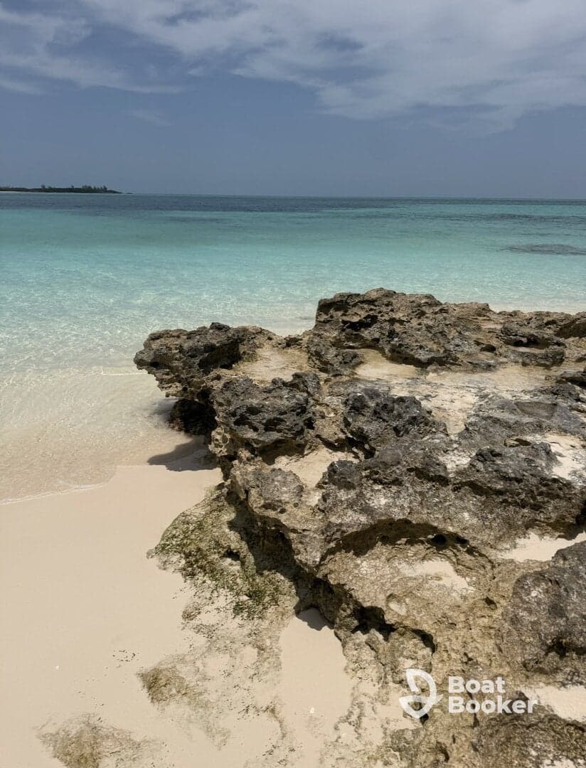 A scenic view of rocky shoreline meeting clear turquoise waters, perfect for beach lovers and nature enthusiasts.