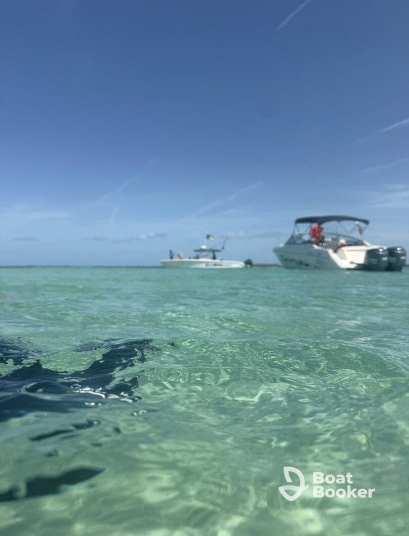A scenic view of two boats anchored in crystal-clear turquoise waters, perfect for a day of relaxation and fun on the water.