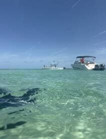 A scenic view of two boats anchored in crystal-clear turquoise waters, perfect for a day of relaxation and fun on the water.
