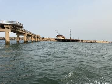 A view of a pier and construction site from the water, lacking clarity and focus.