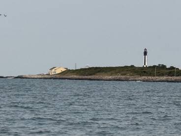 A scenic view featuring a lighthouse and a coastal house, perfect for capturing the beauty of maritime landmarks.