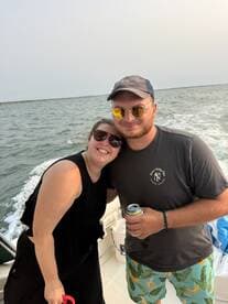 A happy couple enjoys their time on a boat, sharing drinks and smiles against a scenic backdrop — perfect for memorable outings on the water.