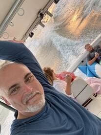 A group enjoys a relaxing moment on a boat, sipping drinks as the sun sets over the water — perfect for memorable outings and celebrations.