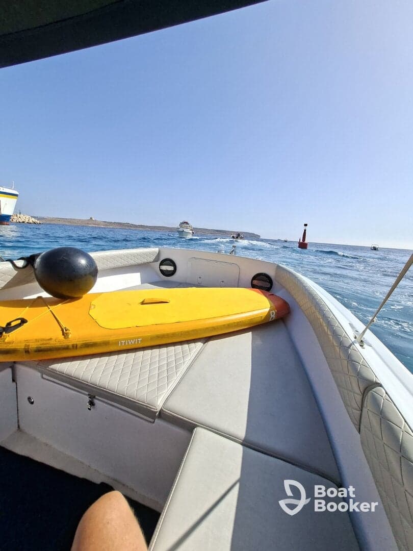 A view of the interior of a boat featuring a paddleboard and comfortable seating, perfect for a day of relaxation and water activities.