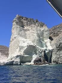 A stunning view of a dramatic coastal rock formation against a clear blue sky, perfect for showcasing the natural beauty of the area.