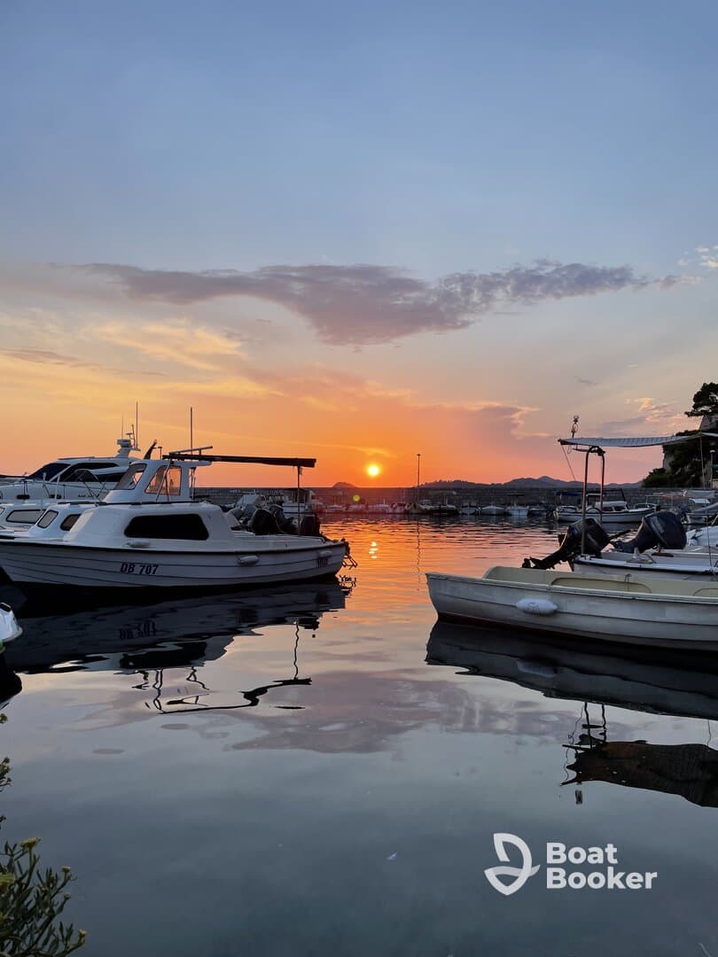 A serene sunset view over a marina with boats gently bobbing in the water, creating a picturesque scene perfect for evening relaxation.