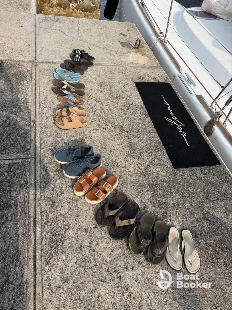 A collection of various shoes lined up on a dock, hinting at a day spent on the water. Perfect for beach outings or boat trips.