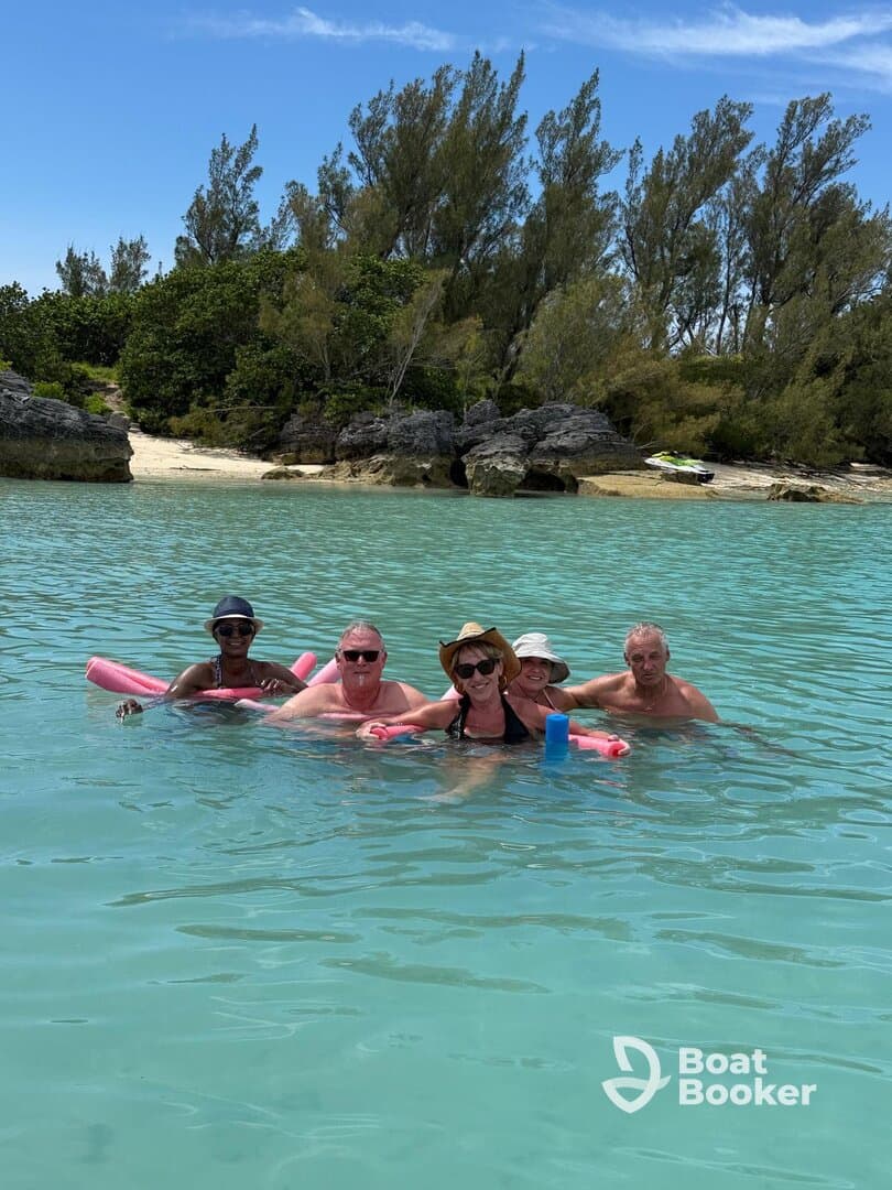 A cheerful group enjoys a refreshing swim in crystal-clear waters, perfect for a day of relaxation and fun at the beach.