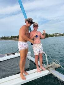 Two friends enjoy a fun moment on the deck of a catamaran, showcasing the perfect atmosphere for a day out on the water.