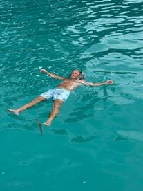 A man enjoys a relaxing swim in crystal-clear turquoise waters, embodying the perfect tropical getaway experience.