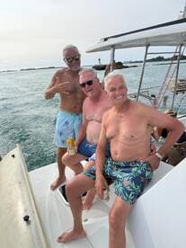 A lively group of friends enjoys drinks on the deck of a boat, capturing the essence of a fun day on the water.