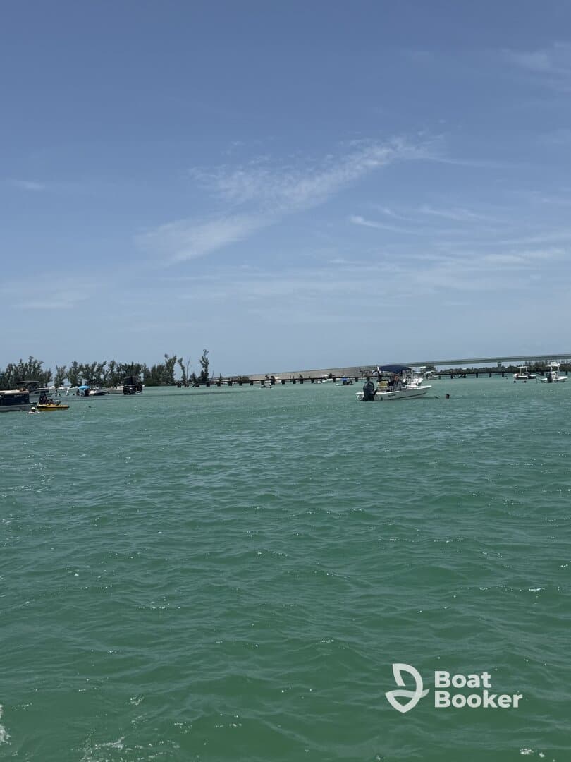 A vibrant scene showcasing multiple boats in turquoise waters near a pier, perfect for enjoying a day on the water.