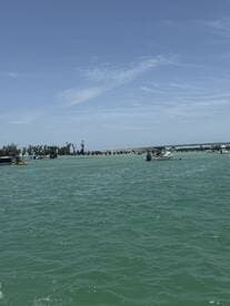 A vibrant scene showcasing multiple boats in turquoise waters near a pier, perfect for enjoying a day on the water.