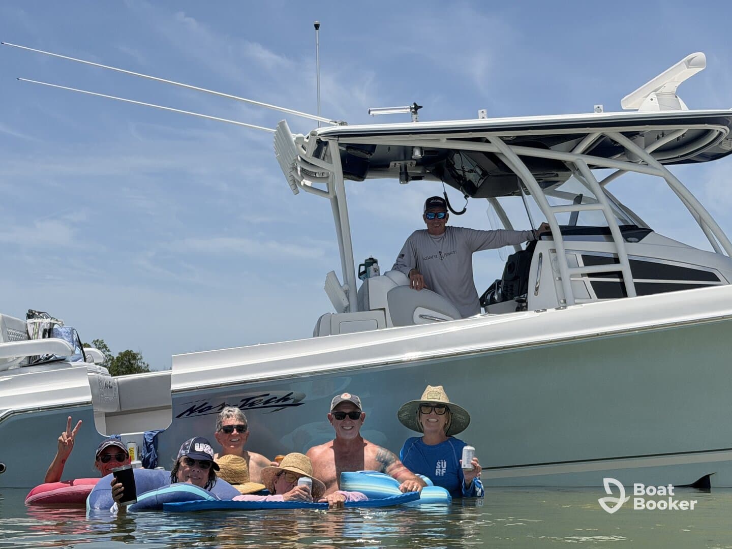A lively group enjoys a fun day in the water, relaxing on floats while the boat is anchored nearby — perfect for summer outings and social gatherings.