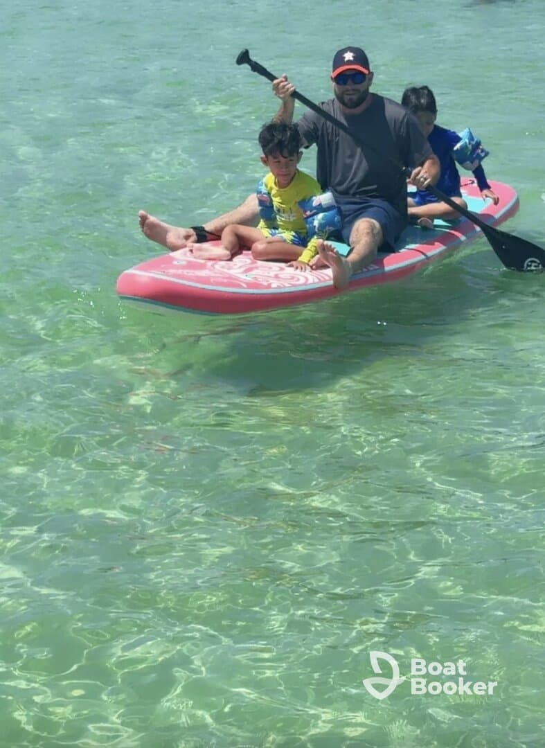 A family enjoys paddleboarding in clear waters, creating unforgettable memories on a sunny day.