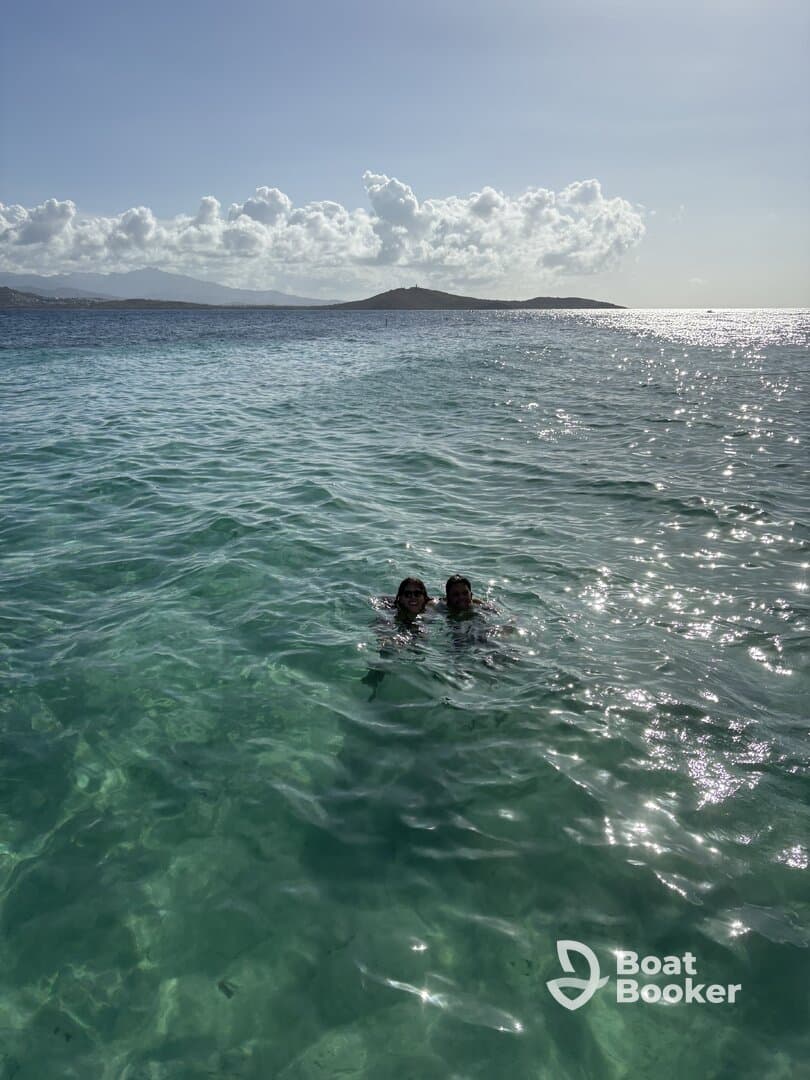 A couple enjoys a refreshing swim in crystal-clear waters, surrounded by stunning scenery — a perfect moment for a tropical getaway.