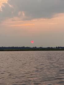 A serene sunset over calm waters, capturing the tranquil beauty of nature — perfect for peaceful evening boat rides.