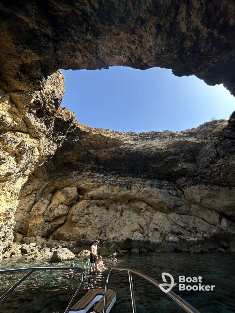 A family enjoys a refreshing swim in a stunning cave setting, surrounded by natural rock formations — a perfect spot for exploration and adventure.
