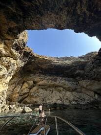 A family enjoys a refreshing swim in a stunning cave setting, surrounded by natural rock formations — a perfect spot for exploration and adventure.