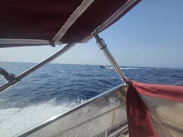 View from the helm of a boat, showcasing the cabin's shade and the open sea ahead, perfect for enjoying a day on the water.