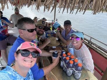 A lively group enjoys drinks and snacks aboard a boat, capturing the essence of a fun-filled day on the water.