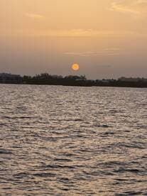 A serene sunset over calm waters, creating a picturesque backdrop for evening boat trips and romantic cruises.