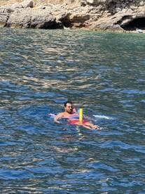 A man enjoys a refreshing swim in crystal-clear waters, showcasing the perfect on-water activity for adventure seekers.
