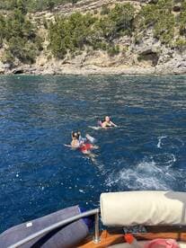 A joyful family enjoys swimming in crystal-clear waters, showcasing a perfect day of fun and relaxation on the boat.