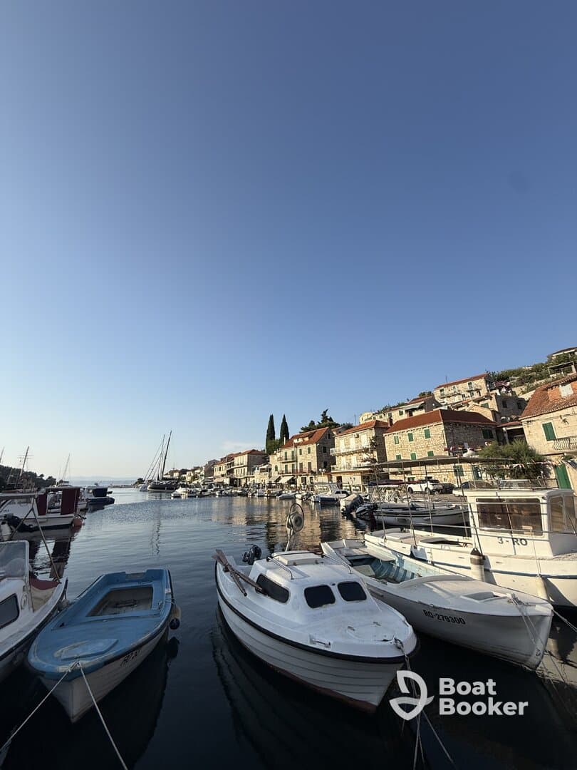 A picturesque view of a harbor filled with various boats, showcasing the charming waterfront architecture and clear blue skies — perfect for boating enthusiasts and travelers.