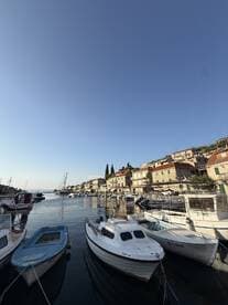 A picturesque view of a harbor filled with various boats, showcasing the charming waterfront architecture and clear blue skies — perfect for boating enthusiasts and travelers.