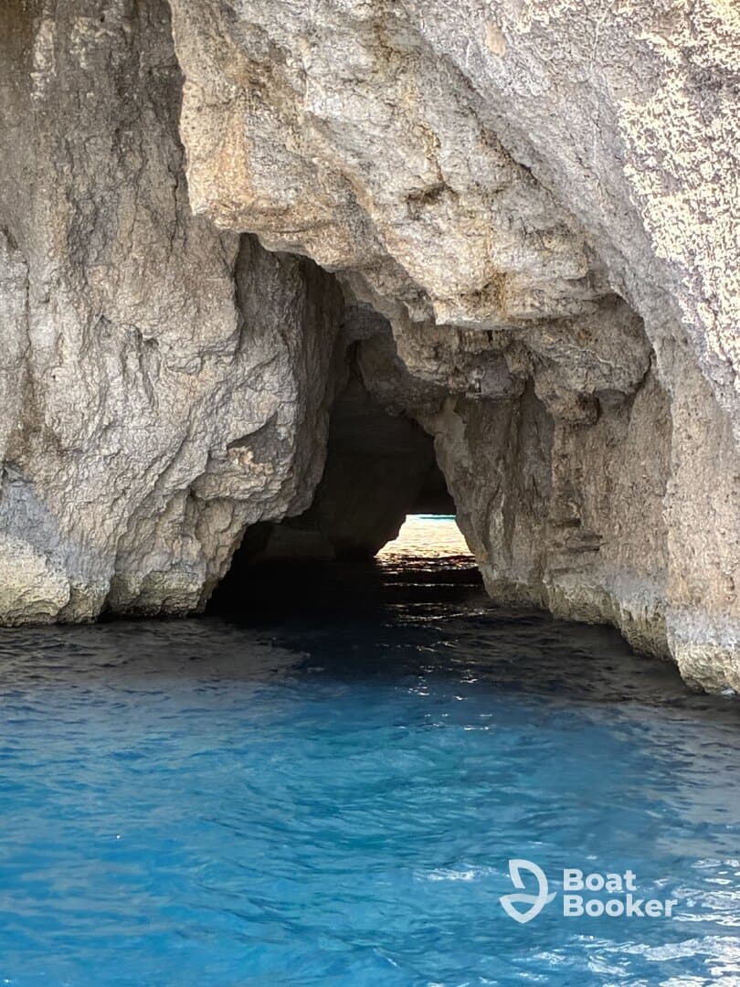 A stunning view of a natural cave entrance surrounded by crystal-clear waters, perfect for exploring coastal wonders and enjoying scenic boat trips.