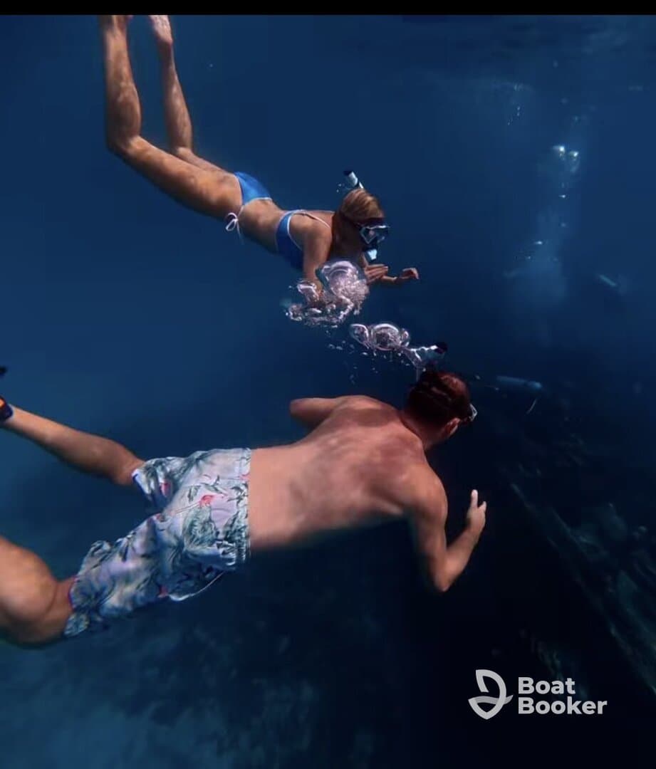 A couple enjoys snorkeling underwater, exploring vibrant marine life and bubbles in a stunning aquatic environment — perfect for adventure seekers.