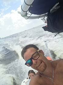 A joyful selfie captures two friends enjoying a day on the water, showcasing the fun and excitement of boating adventures.