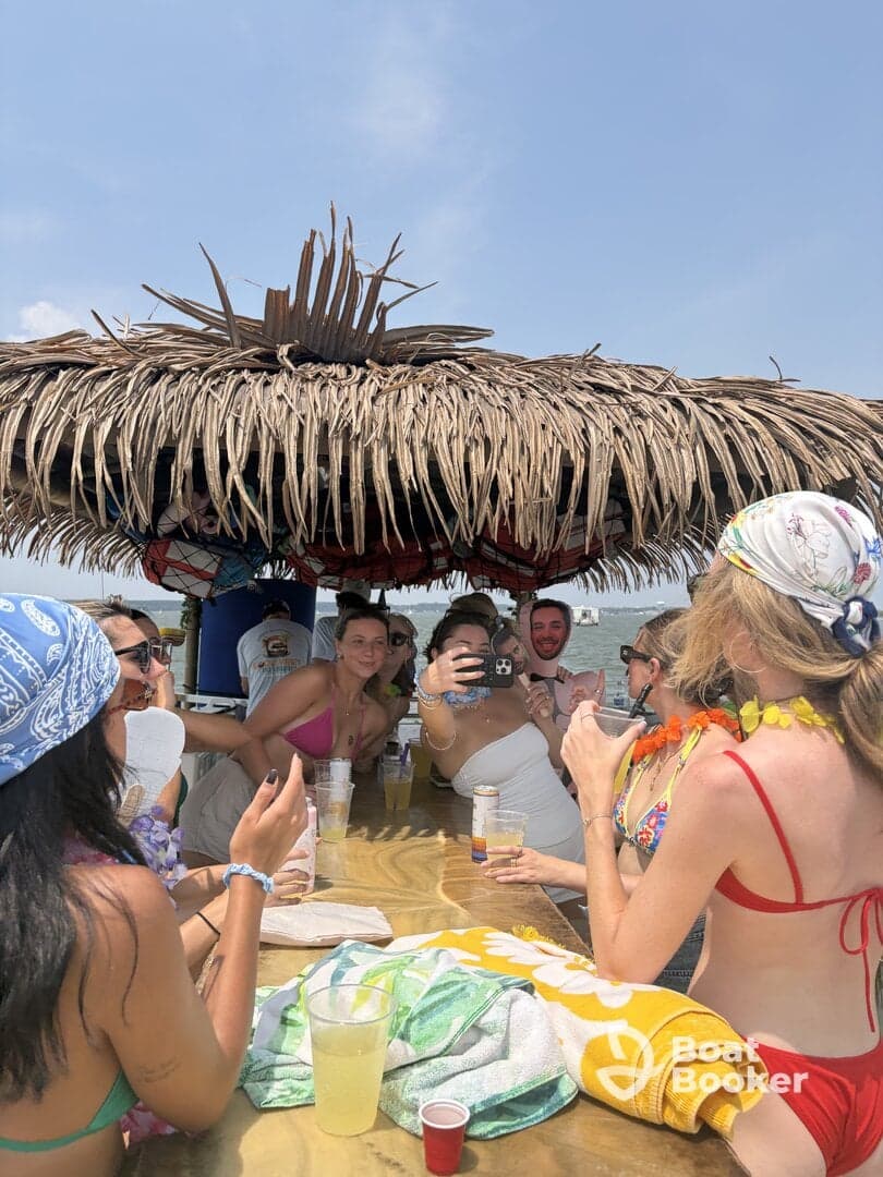 A lively group enjoys drinks and captures memories at a beachside bar, perfect for summer celebrations and social gatherings.