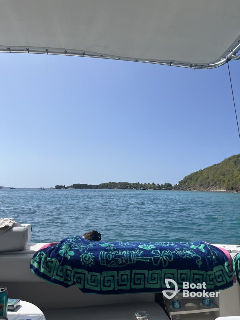 A cozy interior view of a boat featuring a colorful towel draped over the seating area, perfect for relaxing while enjoying the scenic waterfront.