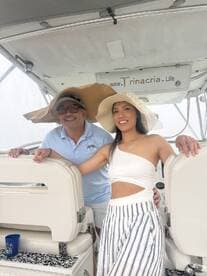 A stylish couple poses on a boat, showcasing their fashionable hats and enjoying a day on the water — perfect for memorable outings and celebrations.