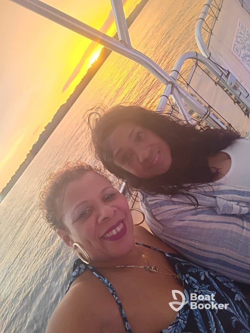 Two friends enjoy a beautiful sunset on the water, capturing a perfect moment of relaxation and celebration aboard a boat.