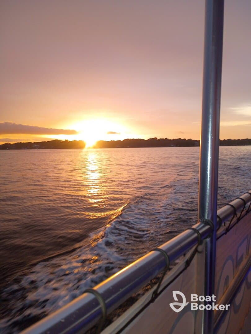 A stunning sunset view from the deck of a boat, showcasing the tranquil waters and vibrant colors of the evening sky — perfect for romantic cruises or peaceful getaways.