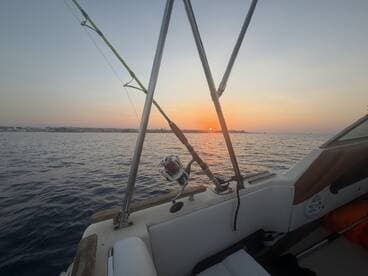A serene view from the helm of a boat as the sun sets over the horizon, creating a picturesque backdrop for evening cruises.