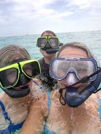 A group of friends enjoys snorkeling in clear waters, showcasing the excitement of underwater exploration and aquatic adventures.
