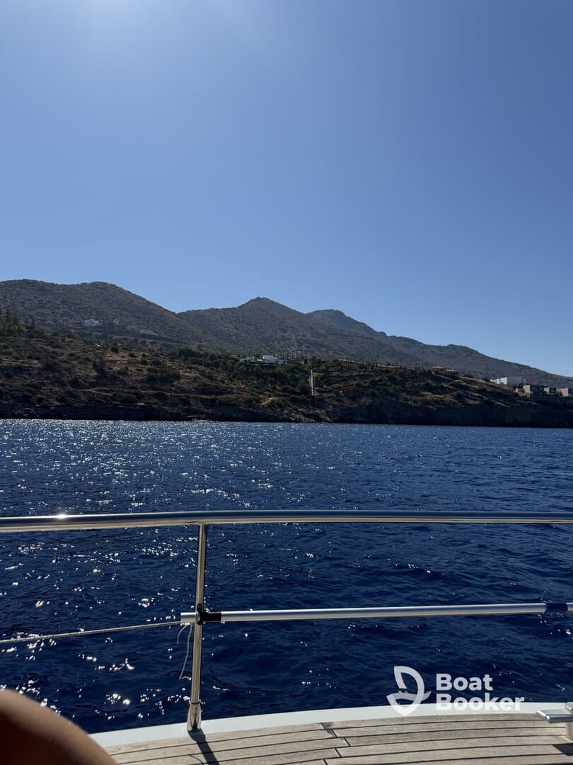 A stunning view of the coastline from a boat, showcasing the sparkling blue waters and mountainous landscape — perfect for capturing the beauty of a day on the water.