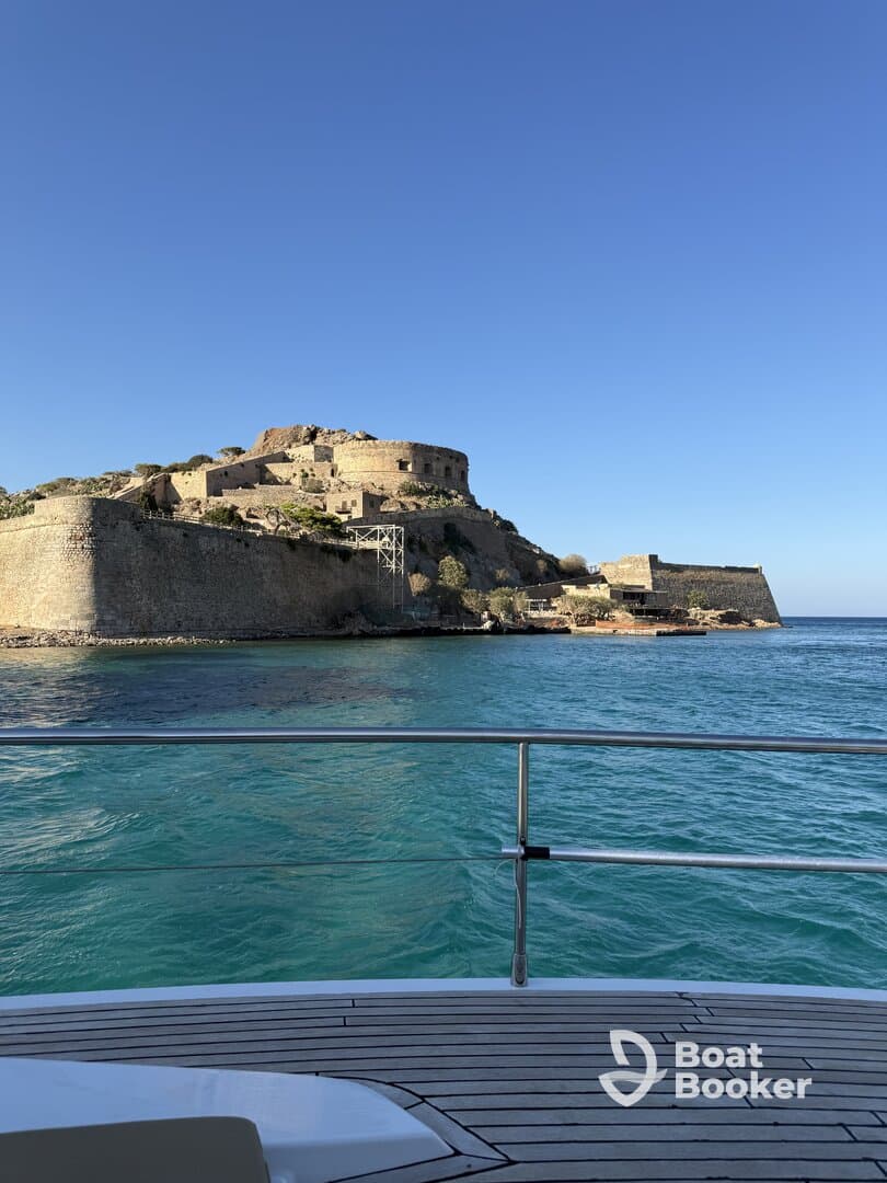 A stunning view of a historic fortress overlooking turquoise waters, captured from the deck of a boat — a perfect backdrop for exploring coastal landmarks.