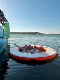 Three friends enjoy a fun day on a floating mat in the water, perfect for relaxation and summer adventures.