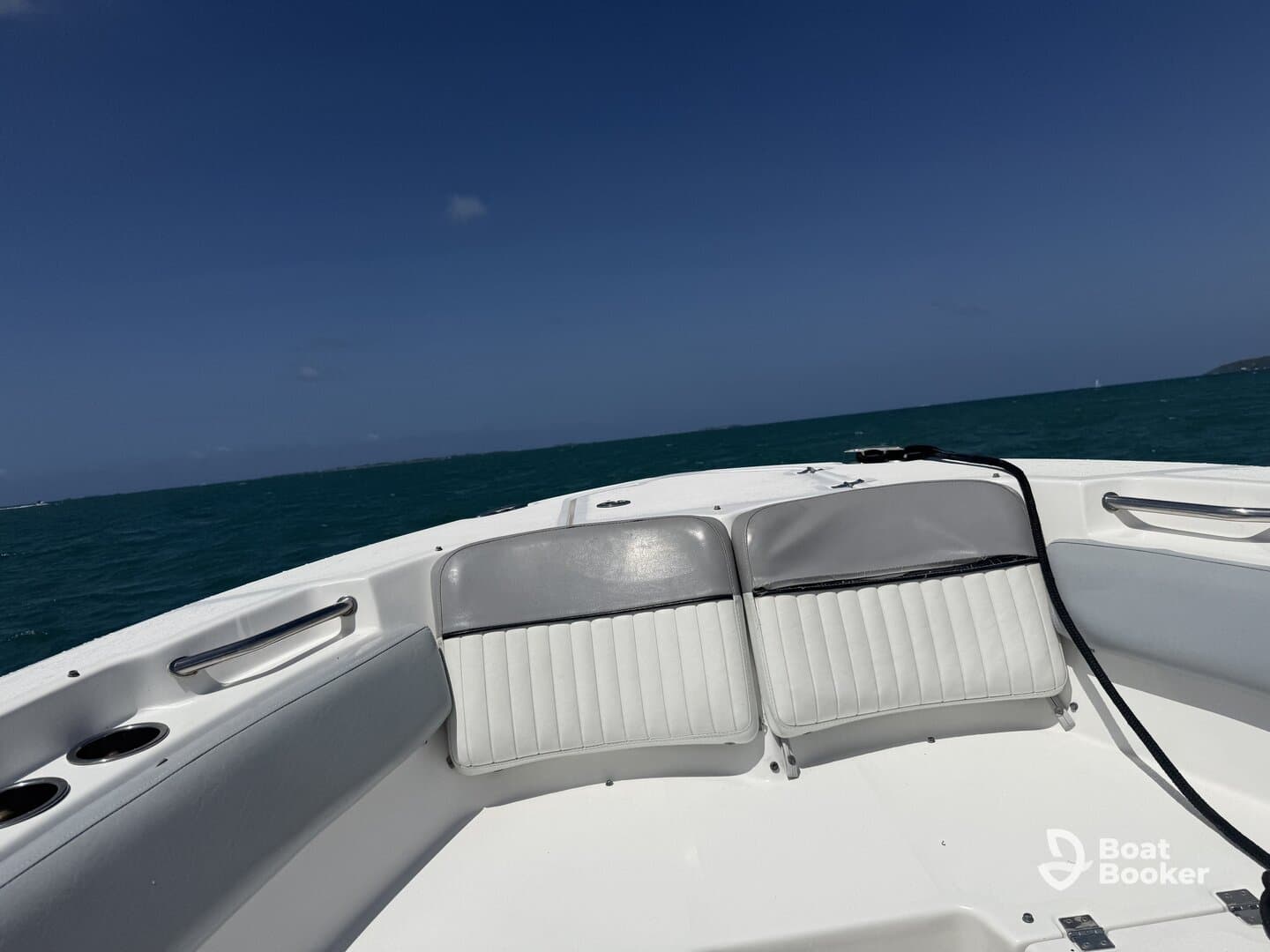 Interior view of a boat's seating area, showcasing comfortable helm seating against a backdrop of turquoise waters — perfect for relaxing while cruising.